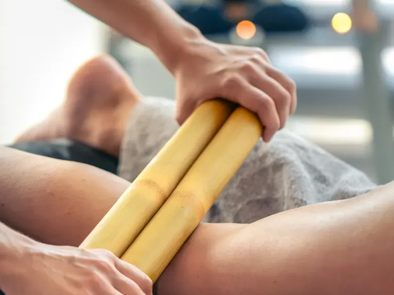 Bambuterapia sendo aplicada nas coxas para contorno e modelagem em Curitiba.