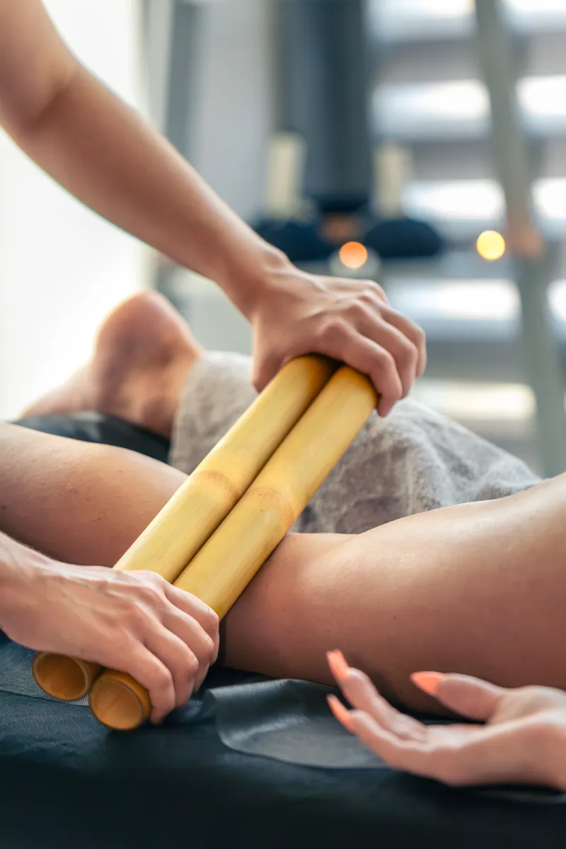 Bambuterapia sendo aplicada nas coxas para contorno e modelagem.